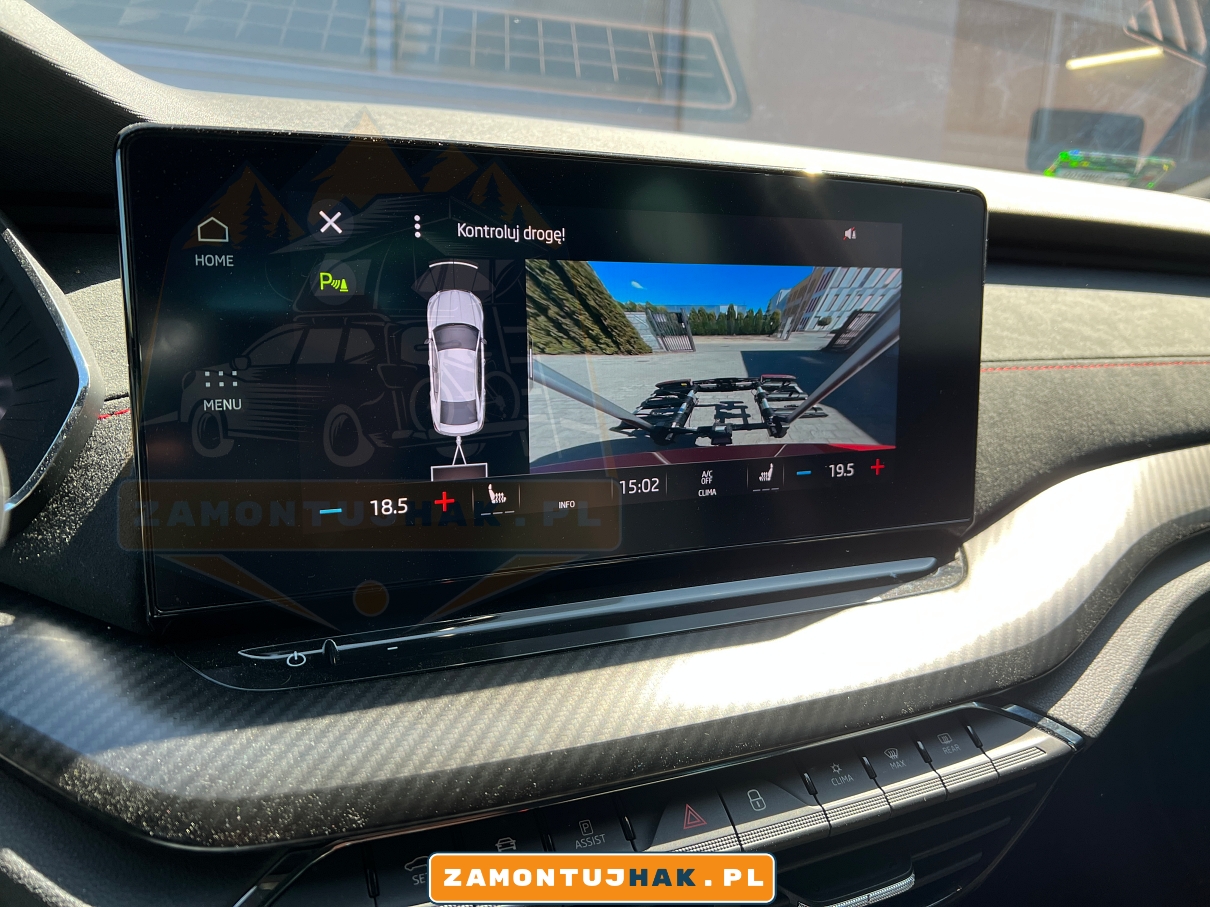 Zdjęcie po kodowaniu instalacji haka holowniczego w skoda octavia rs iv generacji zbliżenie na ekran środkowy na tablicy rozdzielczej pokazuje automatyczne rozłączanie czujników parkowania z tyłu przy jeździe z bagażnikiem rowerowym 